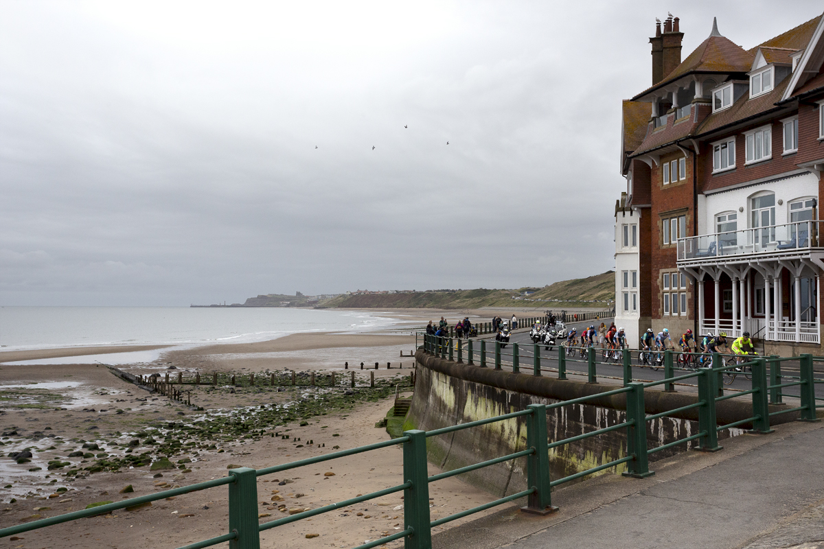 Tour of Britain 2024 - The race rounds a corner on Sandsend sea front