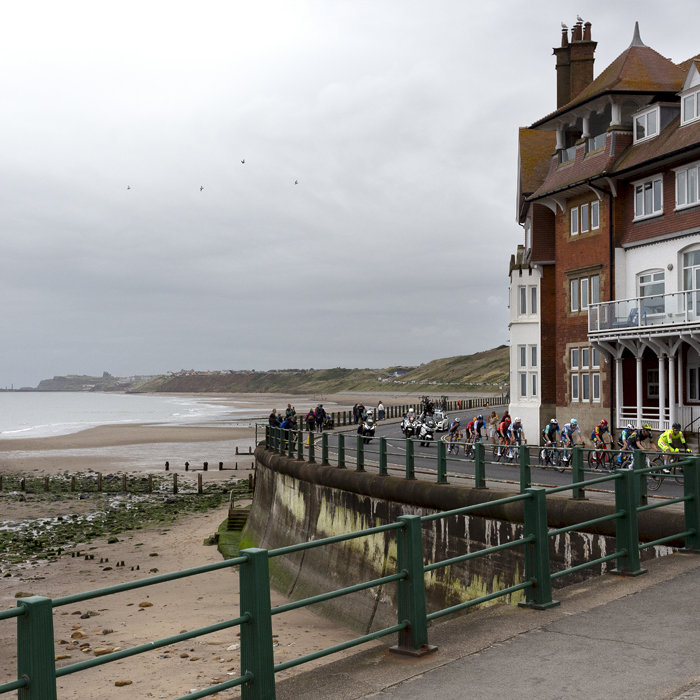 Tour of Britain 2024 - The race rounds a corner on Sandsend sea front