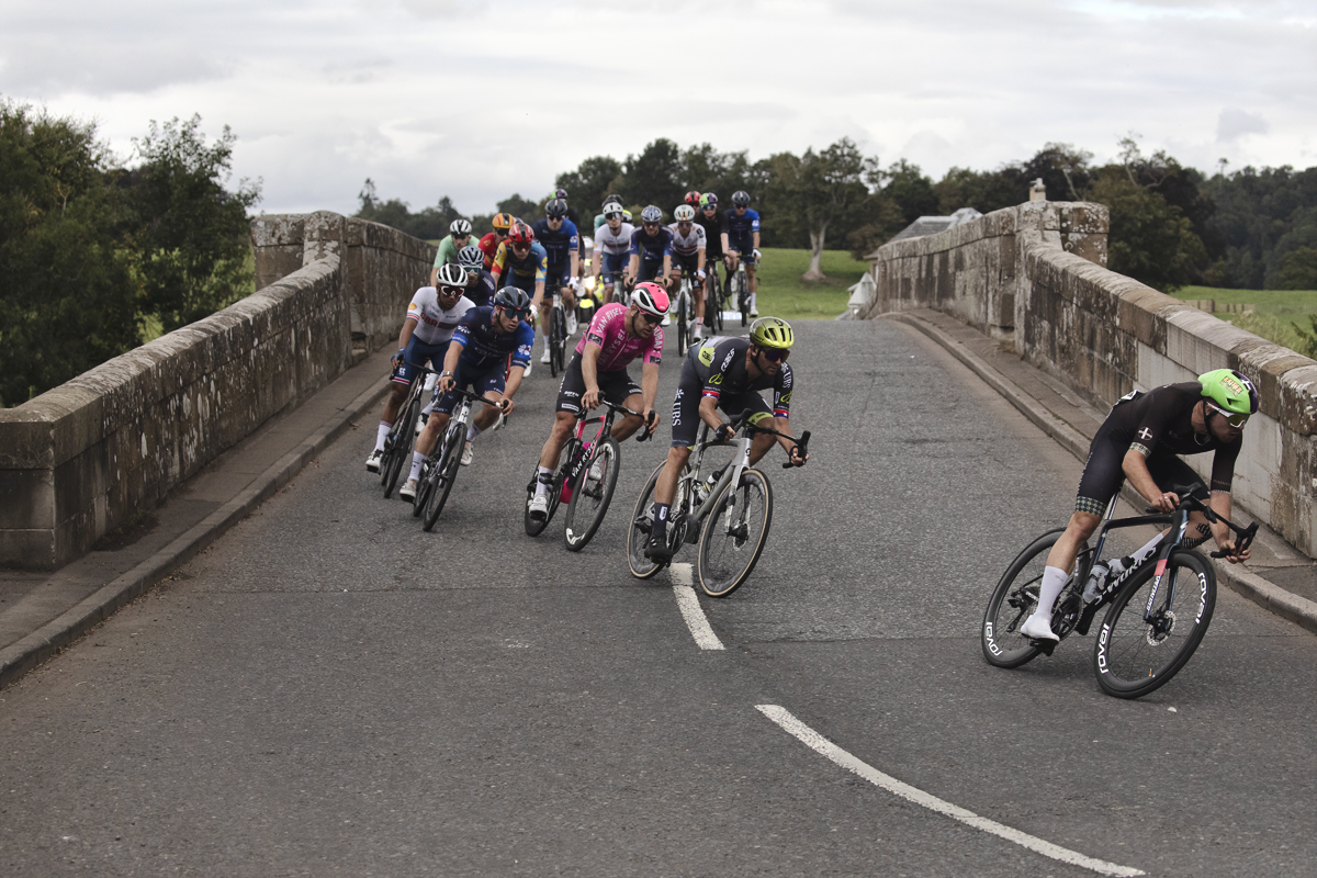 Tour of Britain 2024 - Riders cross Teviot Bridge before taking a tight corner on the way to Kelso