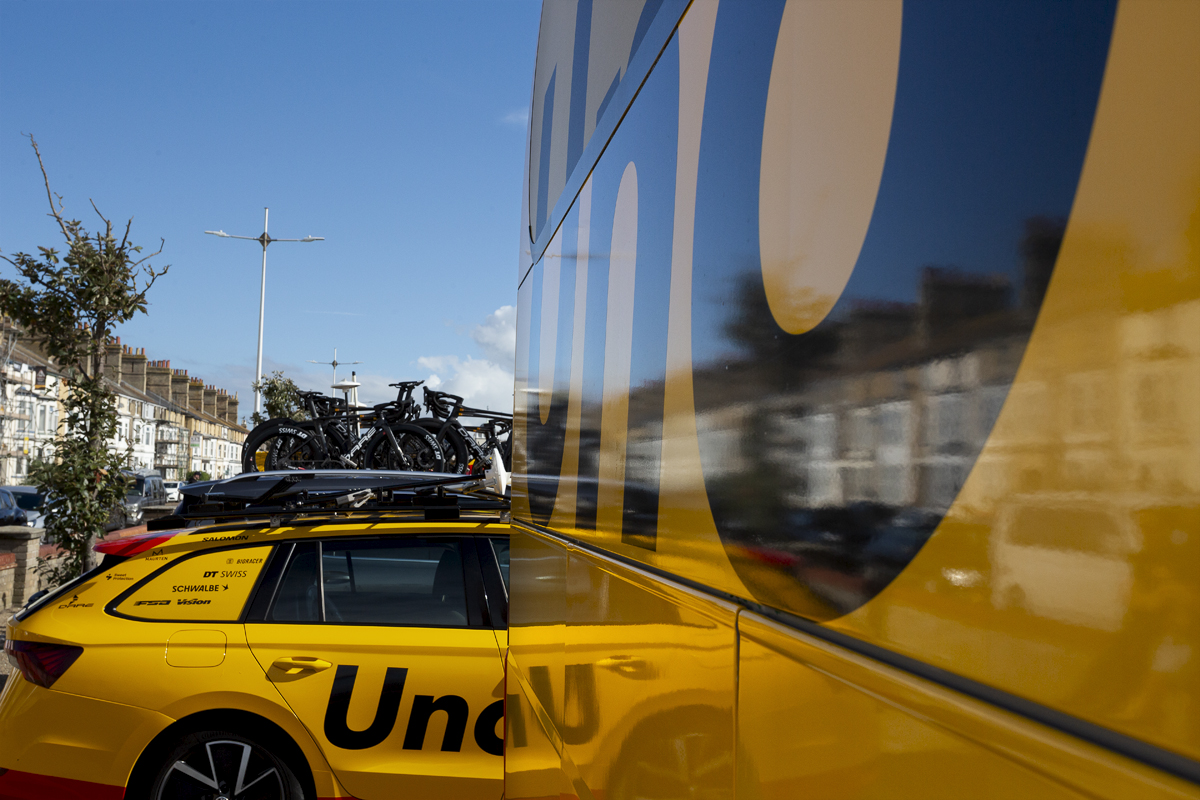 Tour of Britain 2024 - Reflections of the houses in Lowestoft and the team car seen in the UNO-X Mobility team bus