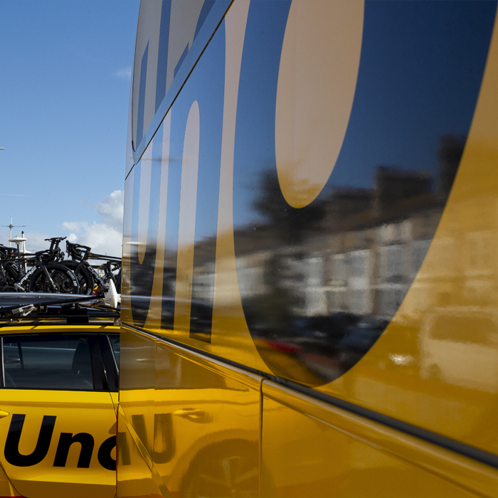 Tour of Britain 2024 - Reflections of the houses in Lowestoft and the team car seen in the UNO-X Mobility team bus