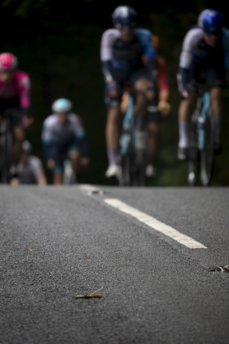 Tour of Britain 2024 - The early signs of Autumn are seen in the shape of a fallen leaf on the road as the peloton approaches outside Wentworth Castle