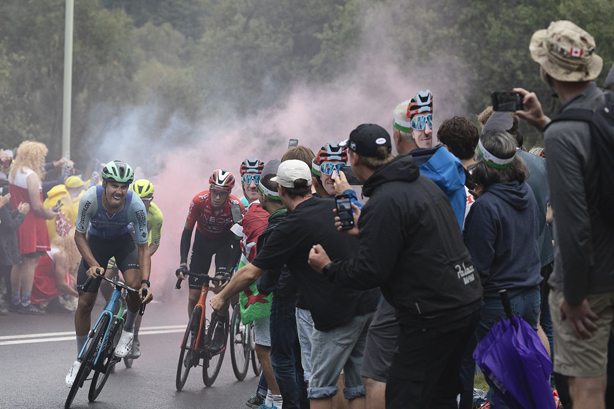 Tour of Britain 2025 - A group of riders make their way up Caerphilly Mountain cheered on by fans wearing Geraint Thomas masks