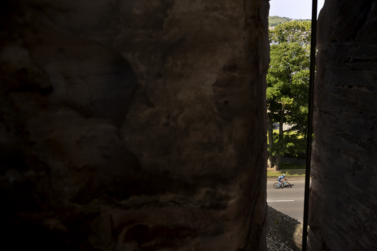 Tour of Britain Women’s 2024 - A rider is framed by one of the arrow slits in Conwy Castle