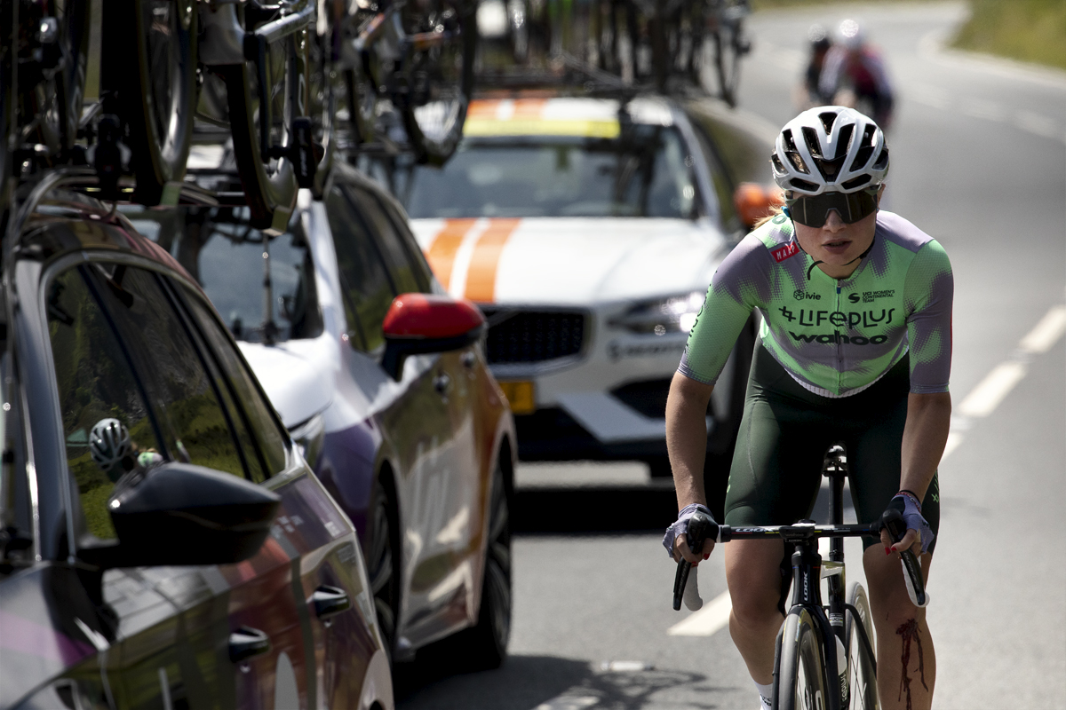 Tour of Britain Women’s 2024 - Karin Söderqvist climbs Horseshoe Pass in the convoy on team cars with blood coming from a wound on her knee