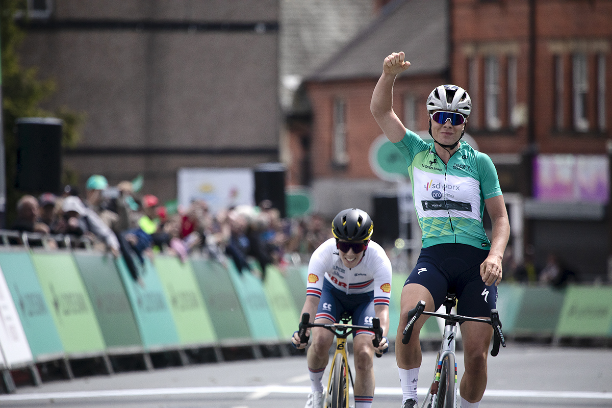 Tour of Britain Women’s 2024 - Lotte Kopecky wearing the leader’s jersey raises her arm as she takes the stage win in Wrexham