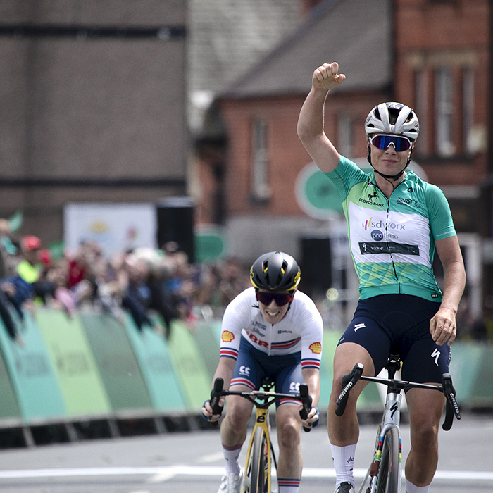 Tour of Britain Women’s 2024 - Lotte Kopecky wearing the leader’s jersey raises her arm as she takes the stage win in Wrexham