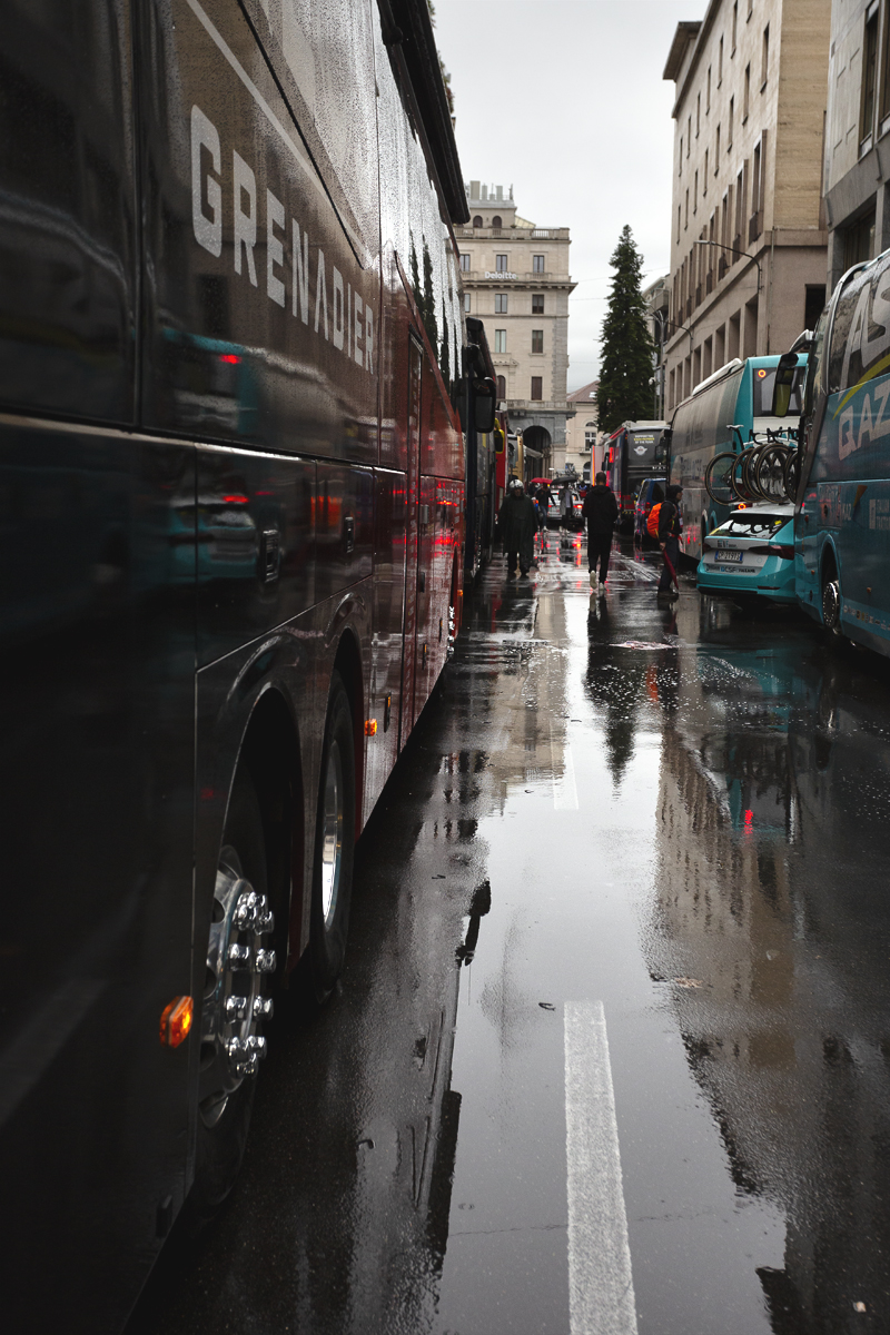 Tre Valli Varesine 2024 - The INEOS Grenadiers bus with the backdrop of Varese  reflected in the wet streets