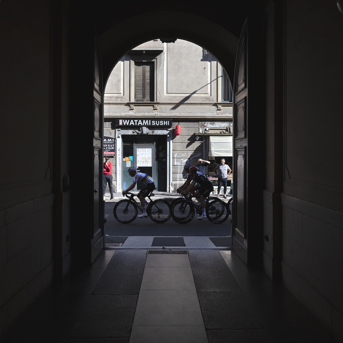 Tre Valli Varesine 2025 - Riders viewed through an archway