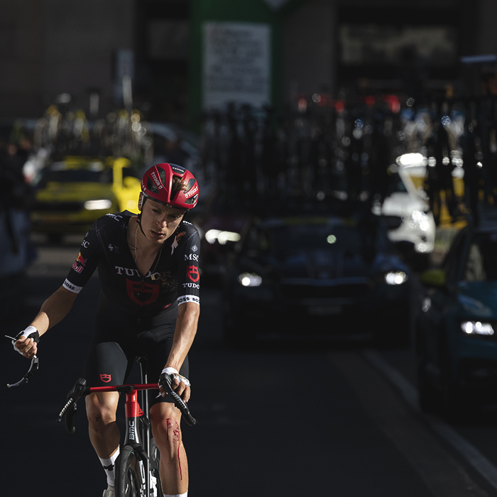 Tre Valli Varesine 2025 - Hannes Wilksch of Tudor Pro Cycling Team with his sunglasses in his hand and a bloody knee following a crash in the race