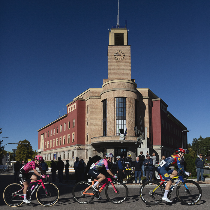 Tre Valli Varesine Women’s Race 2025 - A group of riders pass the art deco style local police headquarters
