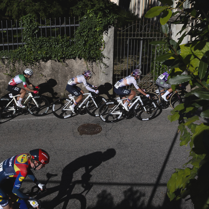 Tre Valli Varesine Women’s Race 2025 - Riders seen from an elevated position as they pass by wrought iron gates covered in ivy