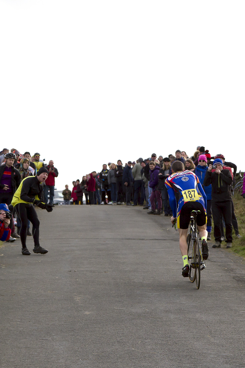 UK National Hill Climb Championships 2015 - Thomas Brook seen from behind as he climbs to the finish while fans line the roadside