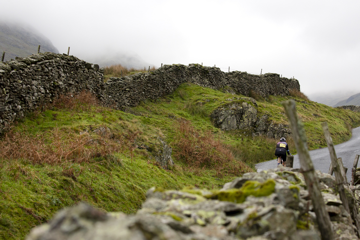 UK National Hill Climb Championships 2023 - Aidan King is seen from behind framed with dry stone walls