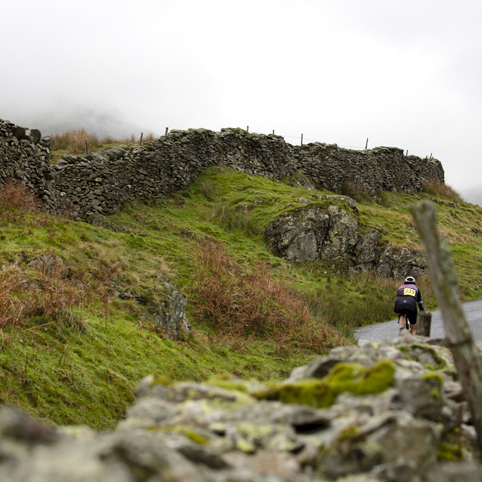 UK National Hill Climb Championships 2023 - Aidan King is seen from behind framed with dry stone walls