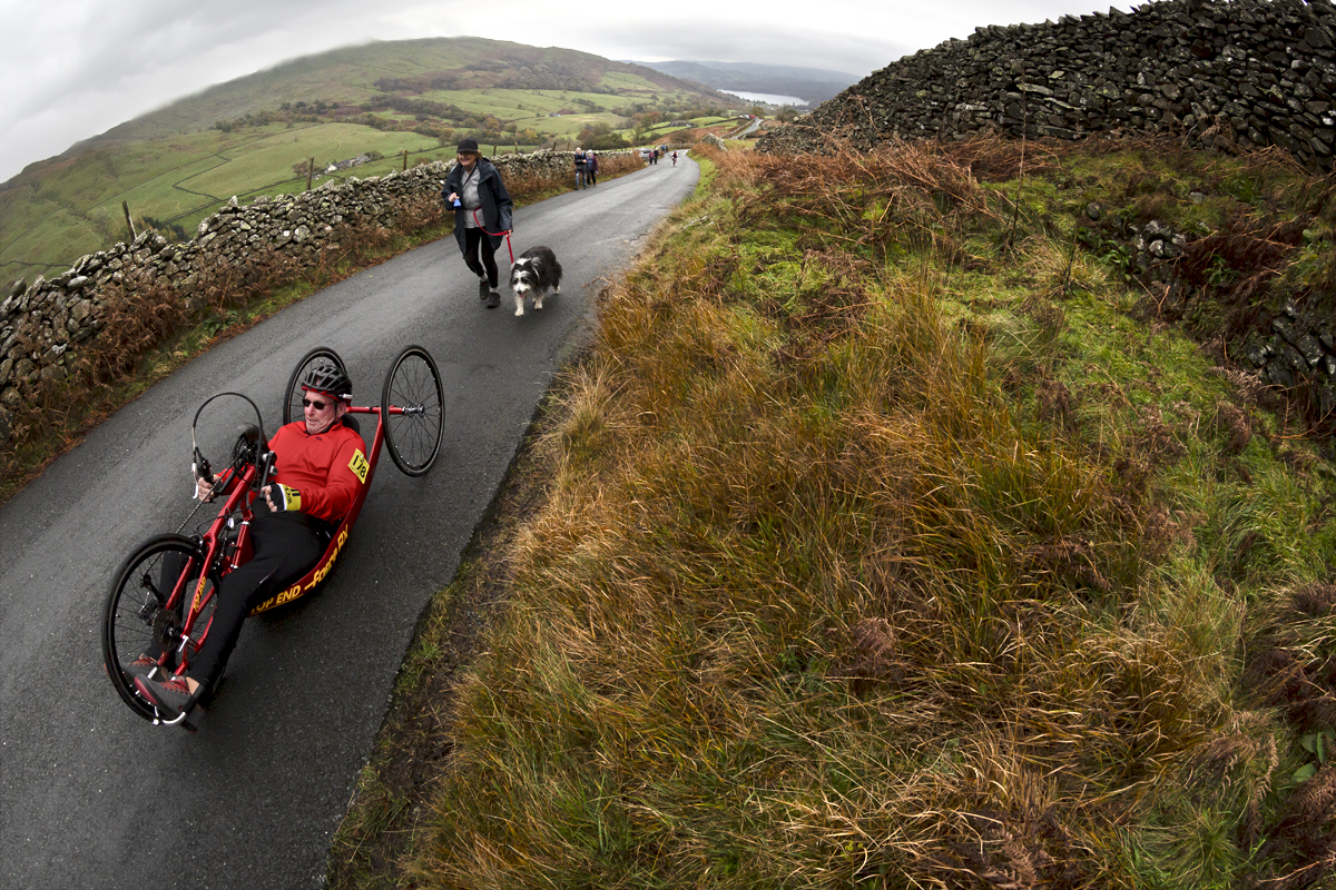 UK National Hill Climb Championships 2023 - Geoff Pickin on a recumbent hand cycle is followed by his wife and dog offering support