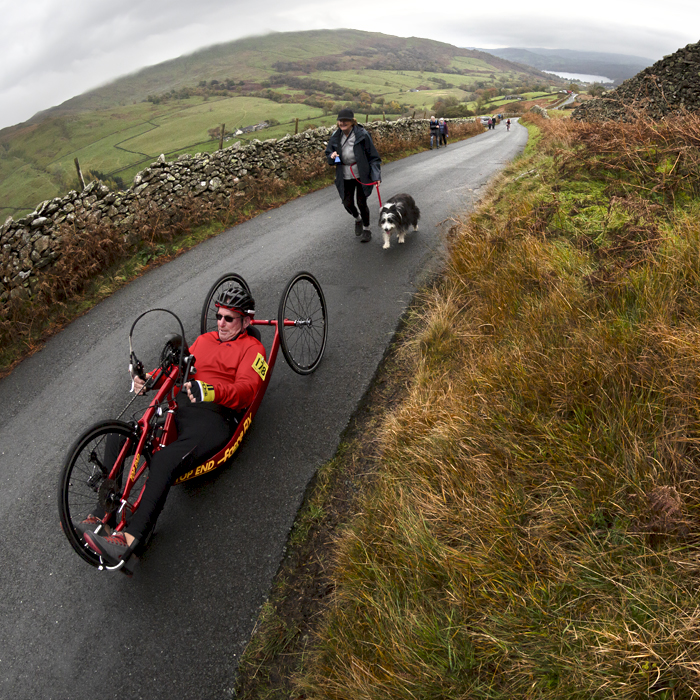 UK National Hill Climb Championships 2023 - Geoff Pickin on a recumbent hand cycle is followed by his wife and dog offering support