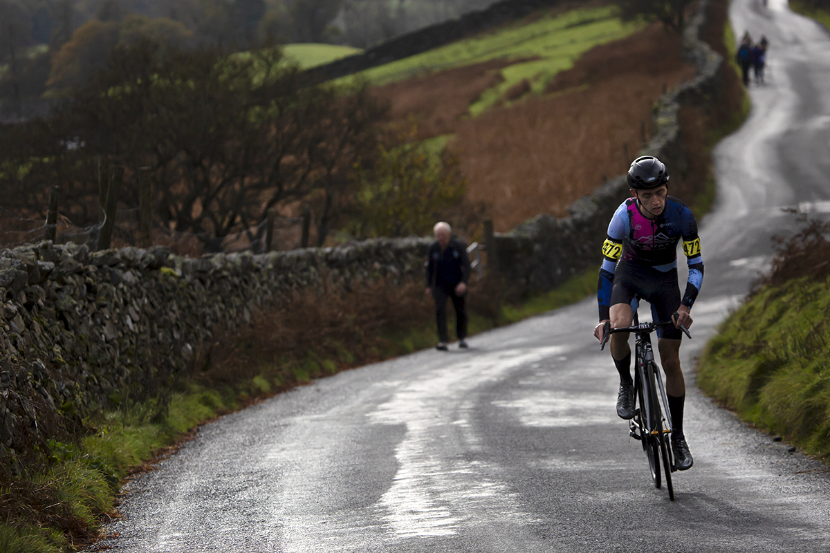 UK National Hill Climb Championships 2023 - Joshua Aiken stands on his pedals as he reaches a steep section of the climb