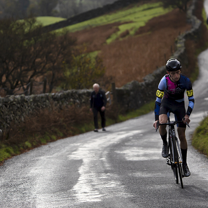 UK National Hill Climb Championships 2023 - Joshua Aiken stands on his pedals as he reaches a steep section of the climb