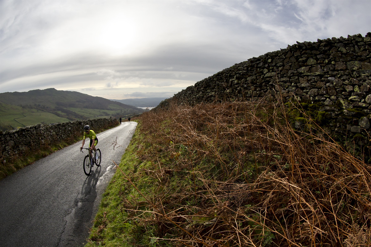 UK National Hill Climb Championships 2023 - Thomas Armstrong passes by dry stone walls with Lake Windermere in the background