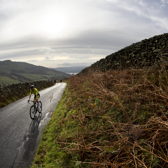 UK National Hill Climb Championships 2023 - Thomas Armstrong passes by dry stone walls with Lake Windermere in the background