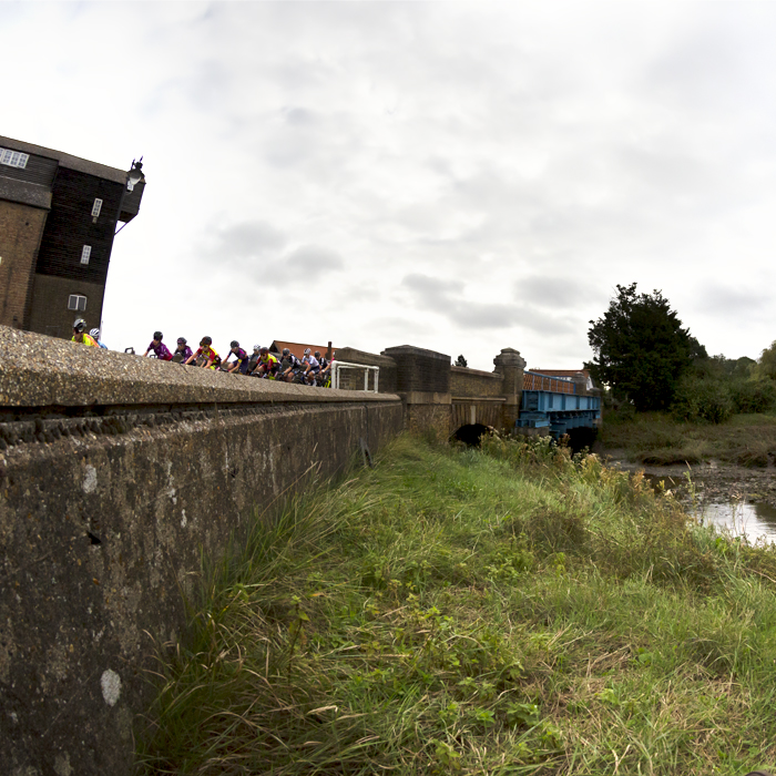 Women’s Tour 2021 - The peloton rides across the bridge with the Mill in the background