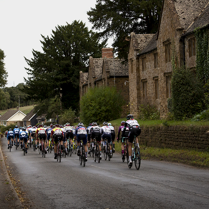 Women’s Tour 2021 - The peloton moves away through Broughton in Oxfordshire past traditional stone cottages