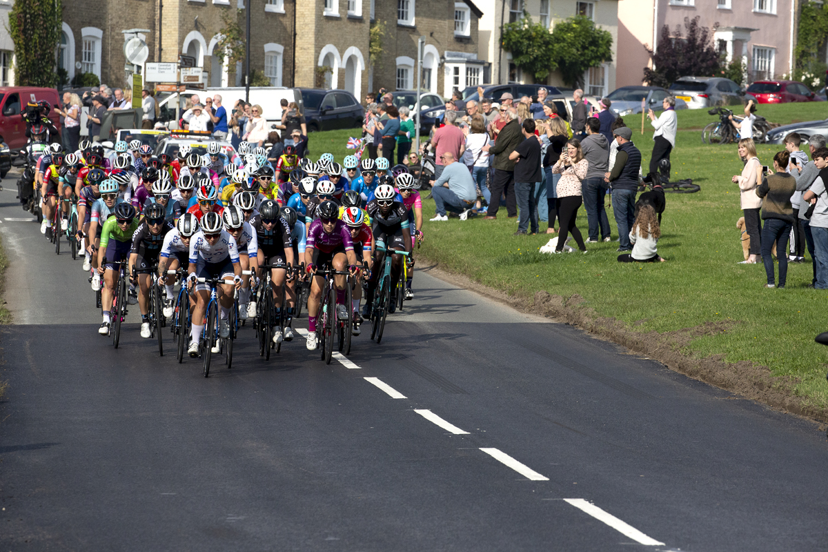 Women’s Tour 2021 - The peloton passes by the village green in Long Melford