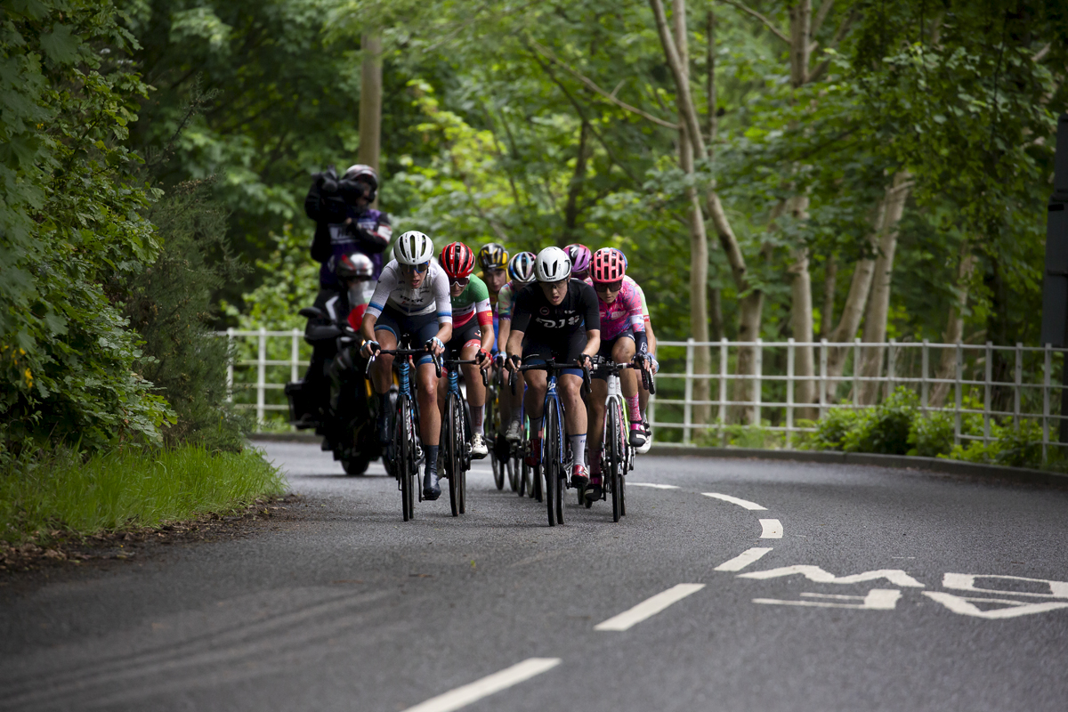 Women’s Tour 2022 - The breakaway followed by the TV camera bike pass under dense trees