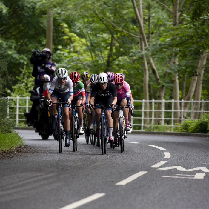 Women’s Tour 2022 - The breakaway followed by the TV camera bike pass under dense trees