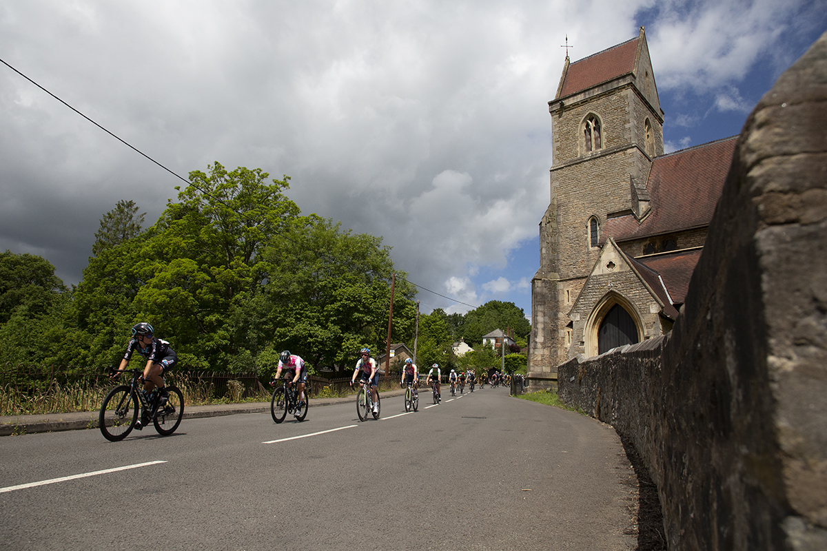 Women’s Tour 2022 - The peloton descend past a church in Lydbrook, Forest of Dean