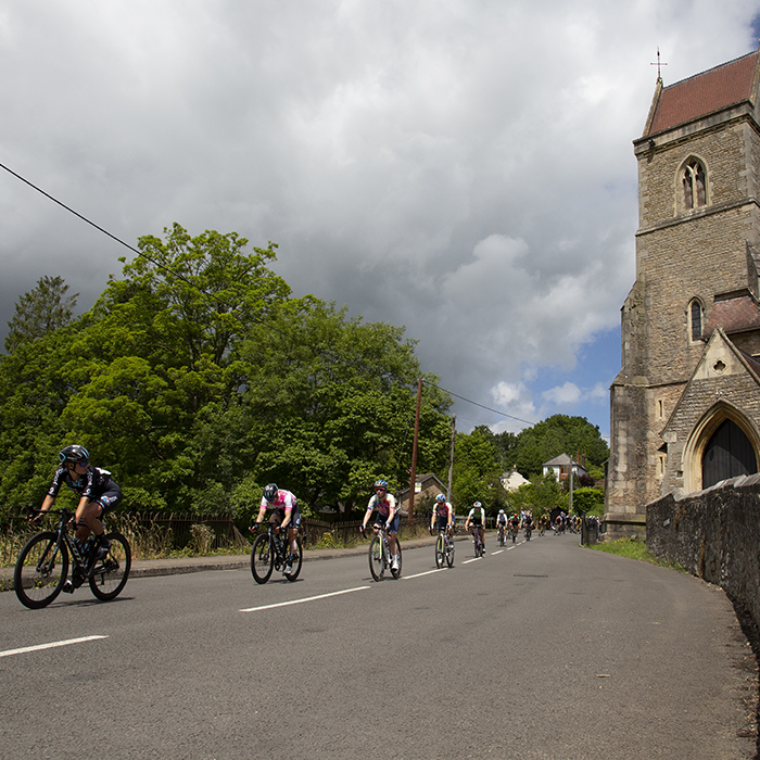 Women’s Tour 2022 - The peloton descend past a church in Lydbrook, Forest of Dean